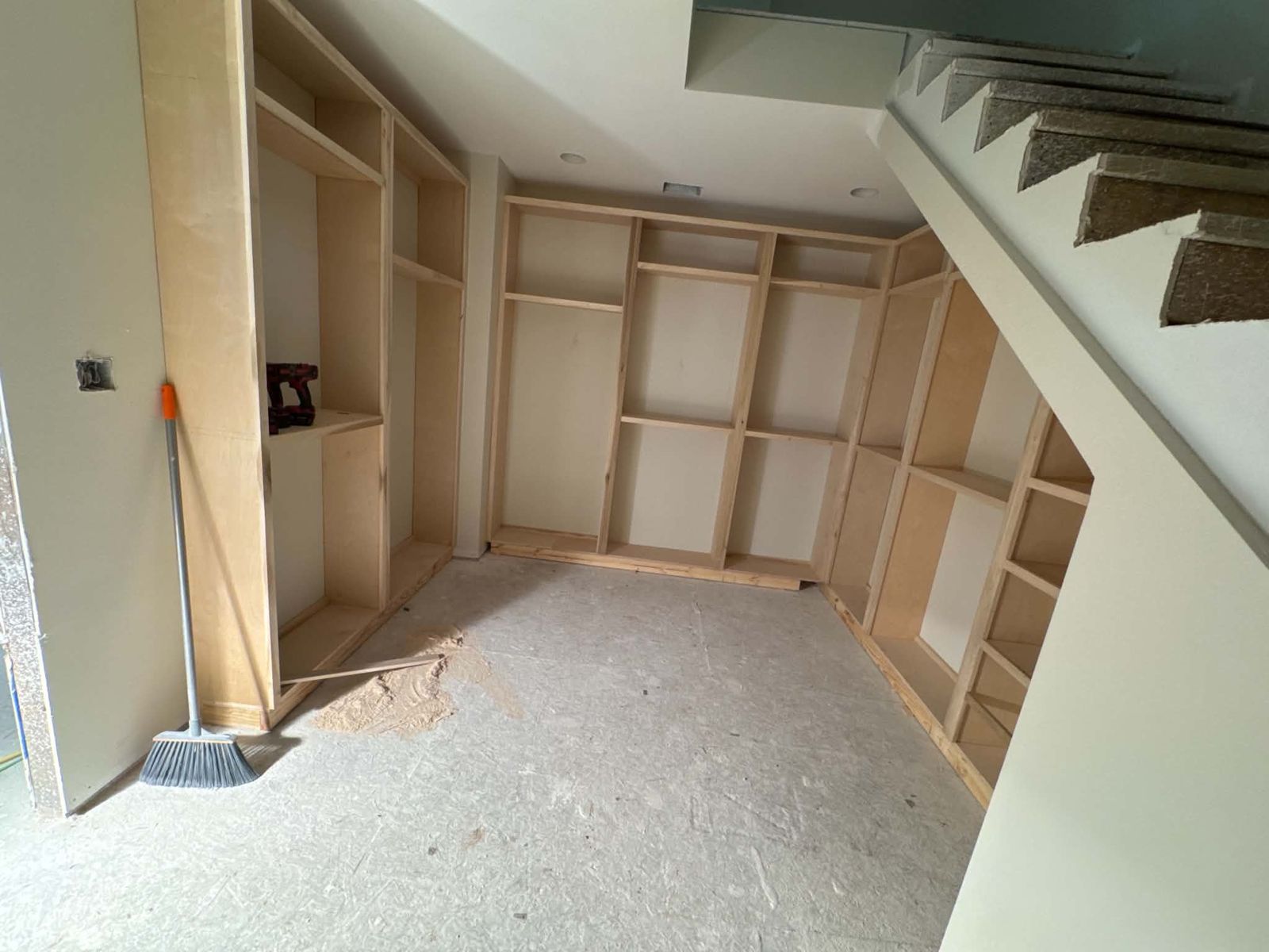 Closet shelving being built under a staircase