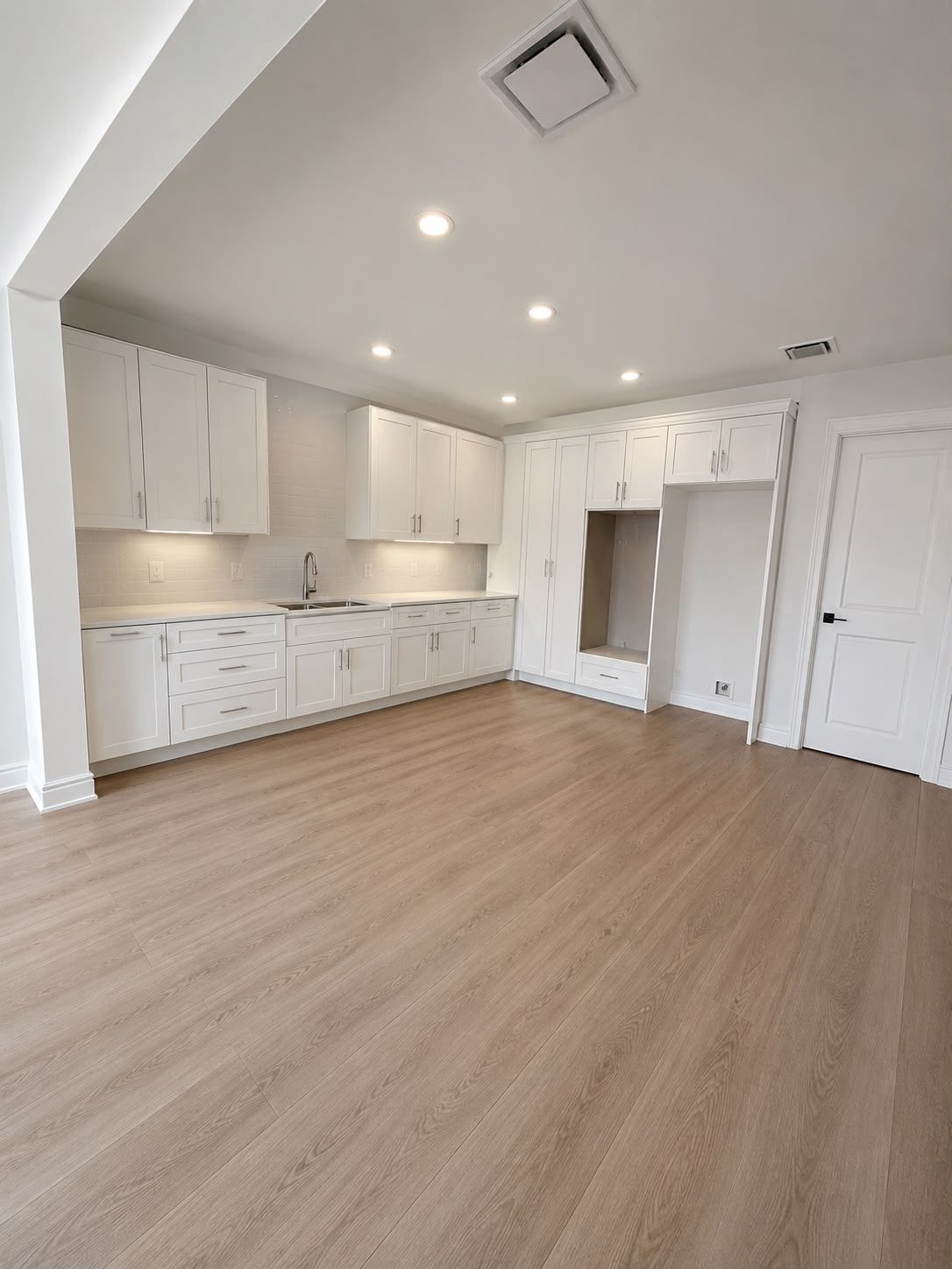 White shaker cabinets with a full pantry wall and built-in bench nook